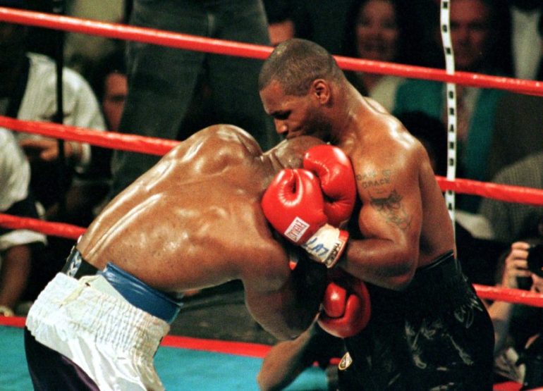 Mike Tyson bites the ear of Evander Holyfield during the third round of the WBA Heavyweight Champion..